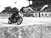 The Velocette in the chicane materialized by straw bales before the grandstand.