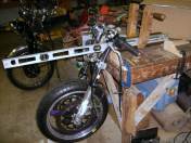 The front fork, wheels and brakes come from a 2003 GSXR 750. As Glen did not have a jig, a big part of the problem was to re-create the right geometry on the bench. Here the front end is positioned to determine the rake and trail. You can see in the background Glen’s 1947 Rapide, which lent its engine for the mock-up phase.