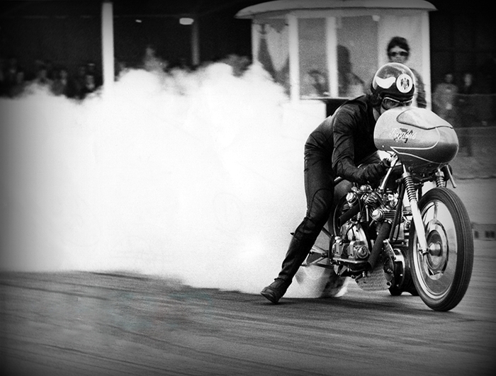 “A great shot of Derek burning the rear slick; this shows the "short" exhaust pipes experimented with for a few meetings. Although they produced a lot of low-end torque, ultimately they didn't improve the elapsed time. 1971 Santa Pod Raceway, UK”. Picture and information © TeamPegasus