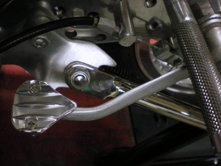 The brake pedal and just behind the side stand.